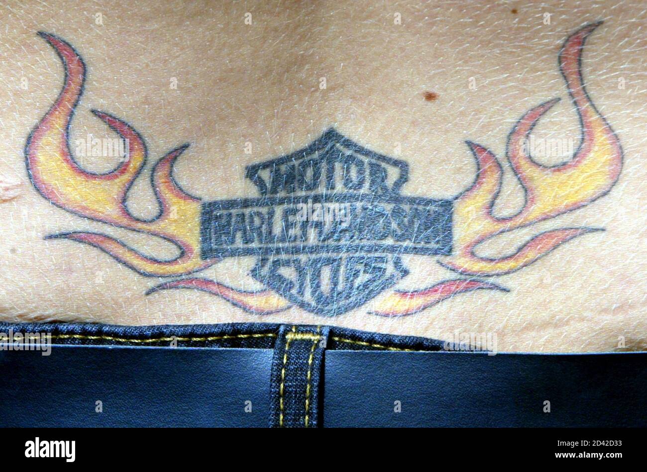 Eine Frau zeigt ein Tattoo auf ihrem unteren Rücken bei der Harley-Davidson Party in der Innenstadt von Milwaukee, 30. August 2003. Das legendäre amerikanische Motorradunternehmen feiert an vier Tagen sein 100-jähriges Jubiläum. Stockfoto