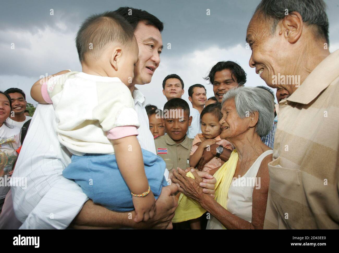 Der thailändische Premierminister Thaksin Shinawatra trägt am 16. Februar 2005 ein Kind bei seinem Treffen mit Dorfbewohnern in der Provinz Yala, 1,200 km (750 Meilen) südlich von Bangkok. Thaksin kam am Mittwoch im weitgehend muslimischen Süden mit einer strengen Botschaft an Dorfbewohner an, die versucht waren, separatistischen Militanten zu helfen. SS/LA Stockfoto