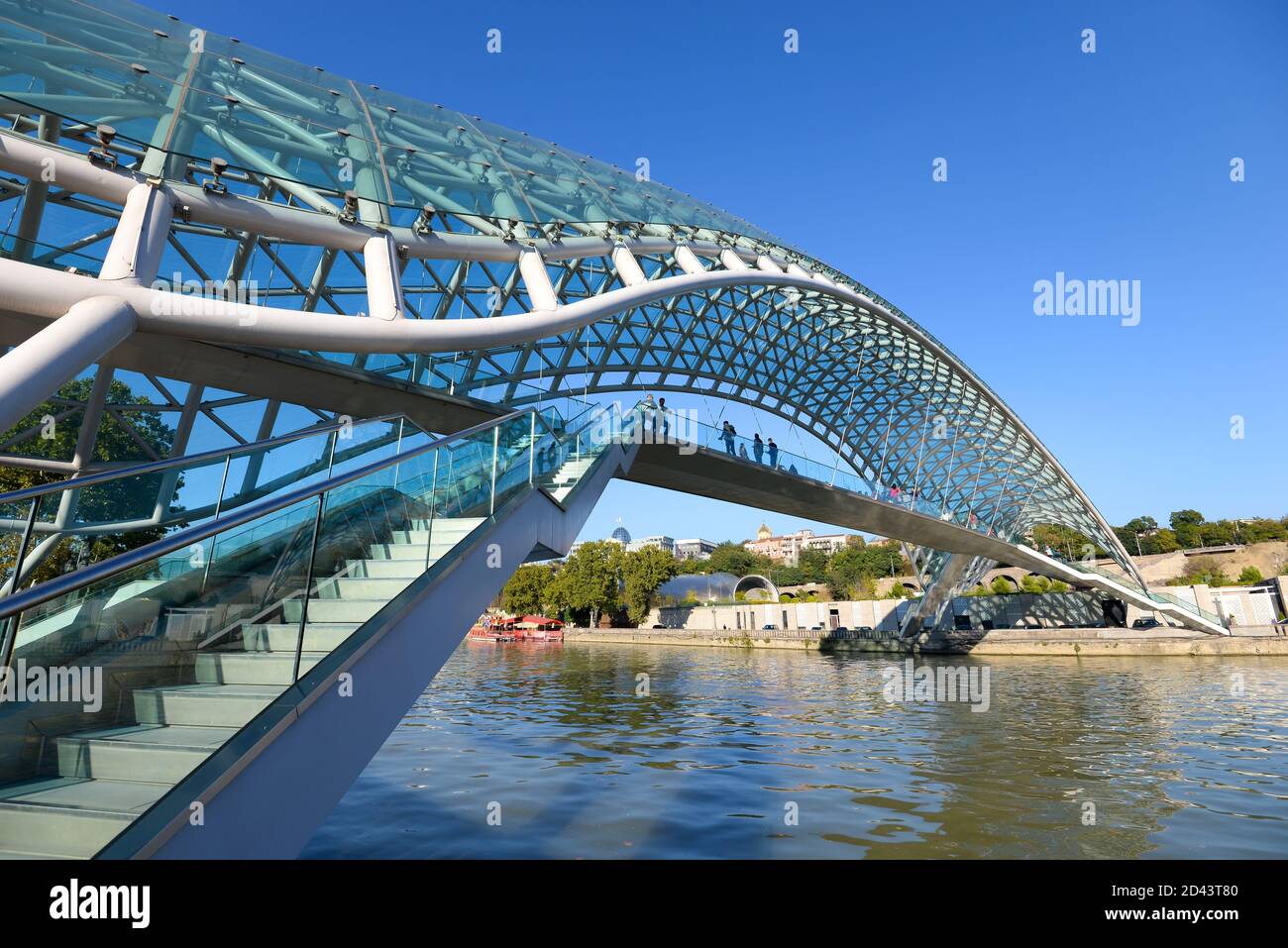 Friedensbrücke in Tiflis, Georgien. Moderne Fußgängerbrücke über den Fluss Kura. Aus kurvigen Stahl und Glas gebaut. Stockfoto