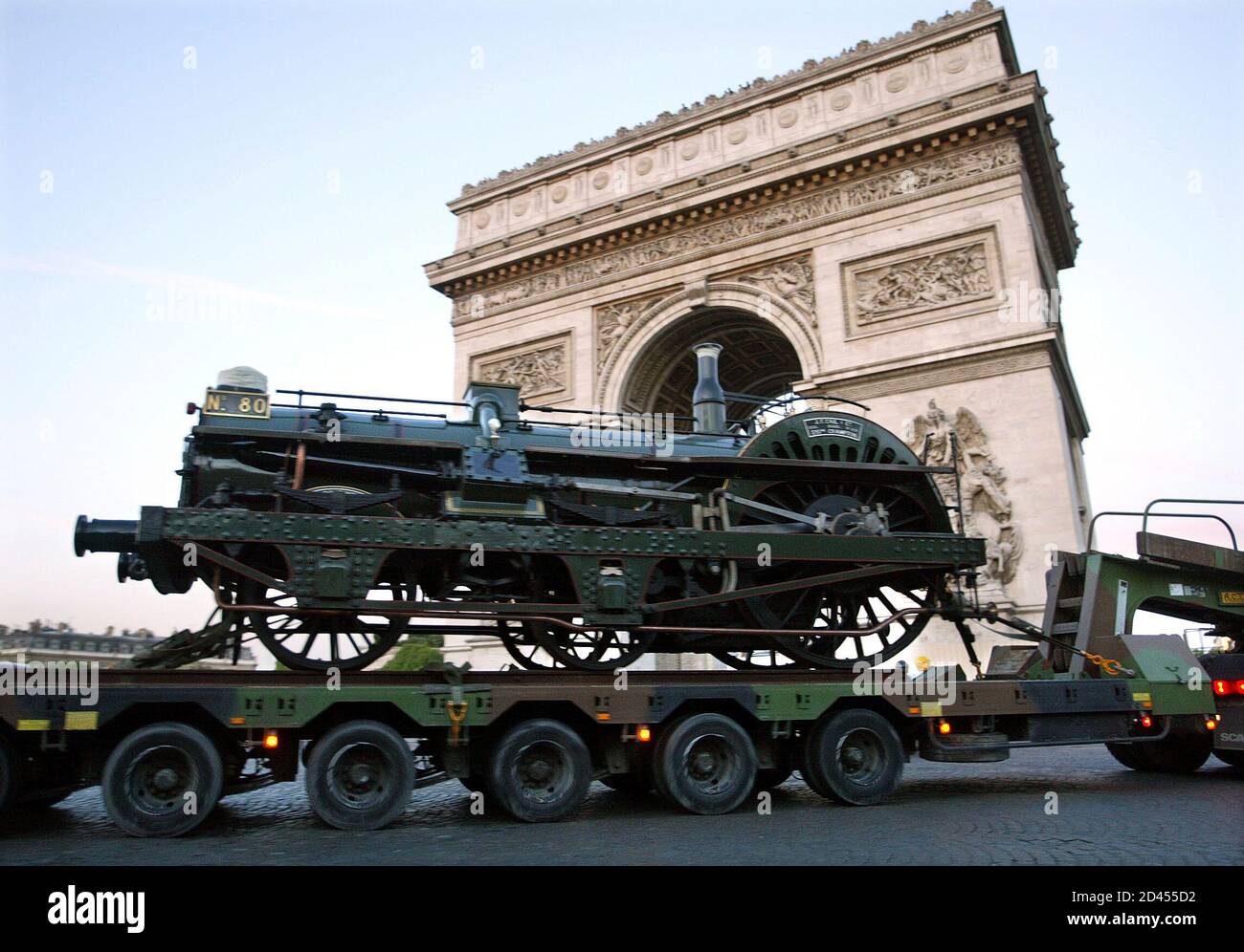 Ein Lastwagen trägt eine alte Lokomotive, während er den Arc de Triomphe von Paris auf seinem Weg passiert, um auf den Champs Elysees, 10. Mai 2003 angezeigt zu werden. Vom 17. Mai bis 15. Juni veranstaltet die französische Eisenbahngesellschaft (SNCF) die Ausstellung "Train Capitale" über den französischen Eisenbahnverkehr. 150 Jahre Bahngeschichte werden von den Lokomotiven der Crampton und Marc Seguin auf den künftigen Triebwagen AGC (AutoRail Grande Capacite) zurückgeführt. REUTERS/Charles Platiau CP/ Stockfoto