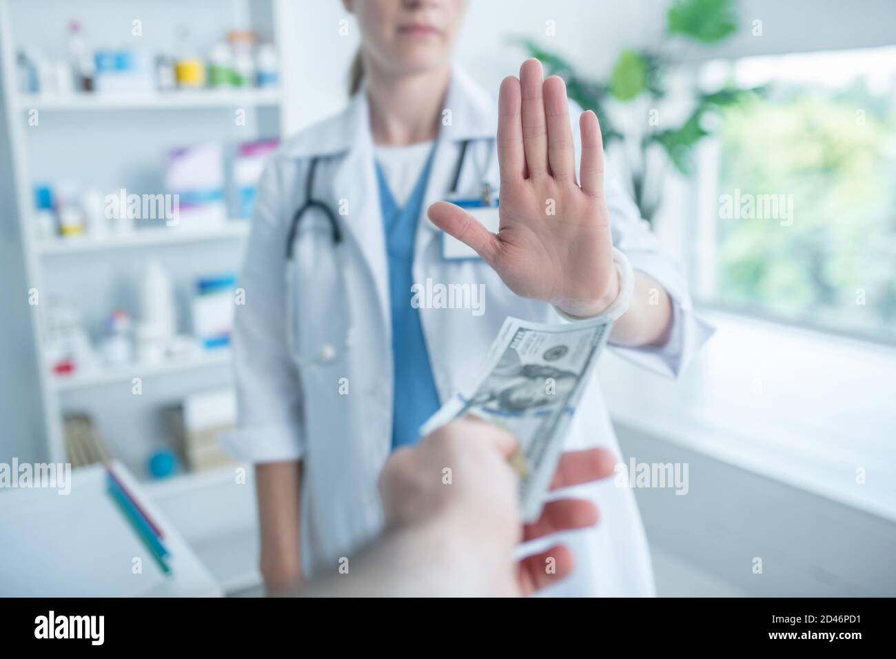 Person in einem Labormantel, die sich weigert, Geld zu nehmen Stockfoto