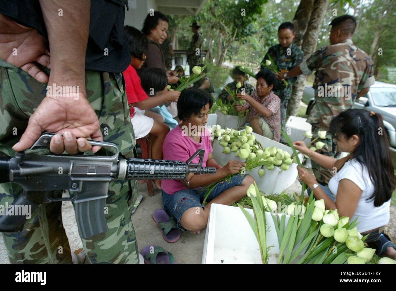 Thai-Buddhisten in muslimischen dominierende Provinz Narathiwat, 1.200 km (750 Meilen) südlich von Bangkok, bereiten Blumen am Khao Gong Tempel am Vorabend des Visakha Puja buddhistischer Feiertag in Südthailand 1. Juni 2004. Thailands Sicherheit Minister führen buddhistischen Anhänger in einer Zeremonie am Mittwoch zum Gedenken an die Geburt, Erleuchtung und Tod von Lord Buddha, in der unruhigen muslimischen Region. REUTERS/Sukree Sukplang SS/SH Stockfoto