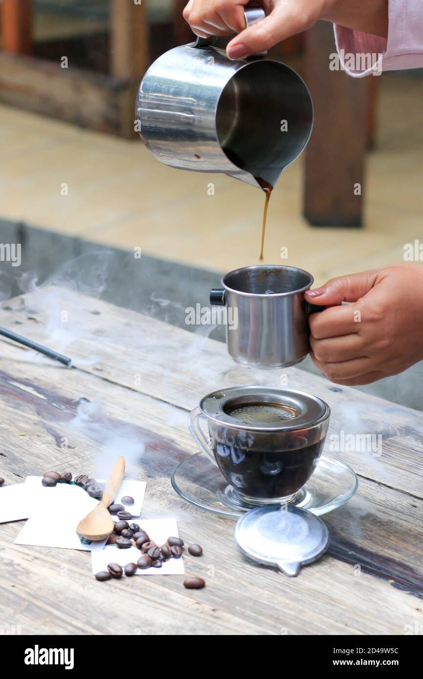 Eine Tasse vietnamesischen Kaffee auf einem hölzernen Café-Tisch. Kaffee, der noch warm ist. Kaffee Pausen während des Tages Stockfoto