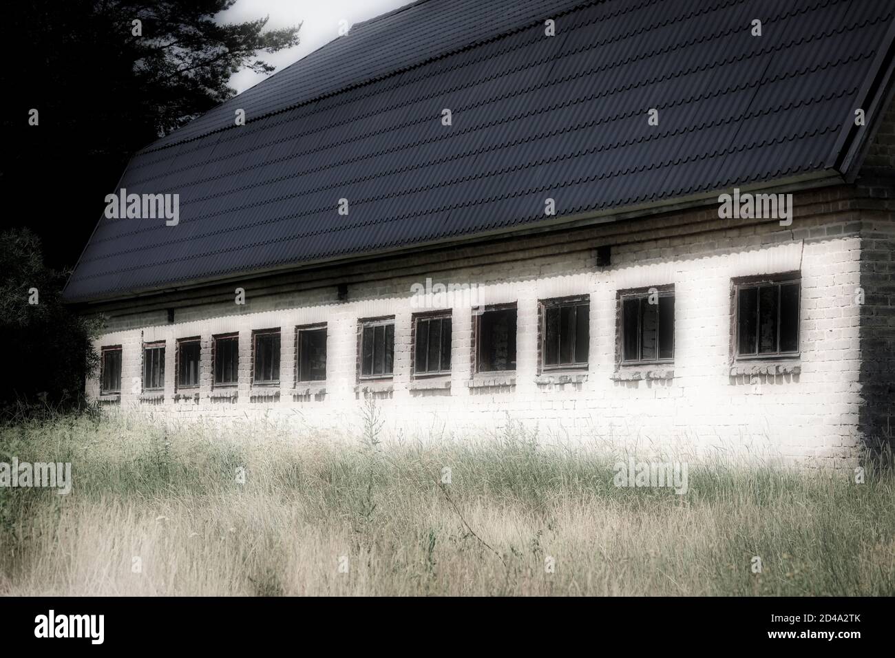 Die Backsteinmauer und die Fenster eines alten Bauernhauses. Stockfoto