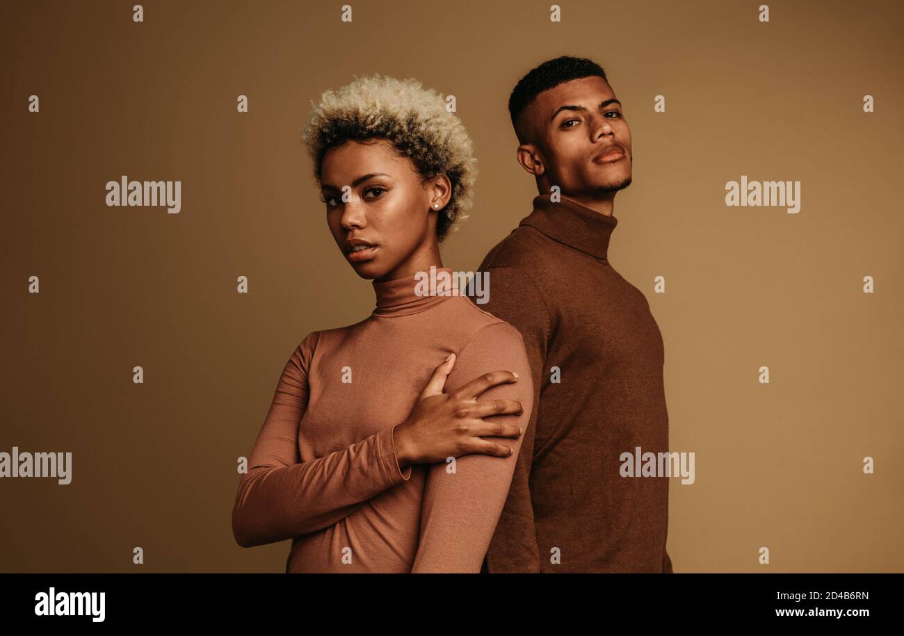 Paar in modischer Winterkleidung. afroamerikanisches Paar auf braunem Hintergrund. Stockfoto