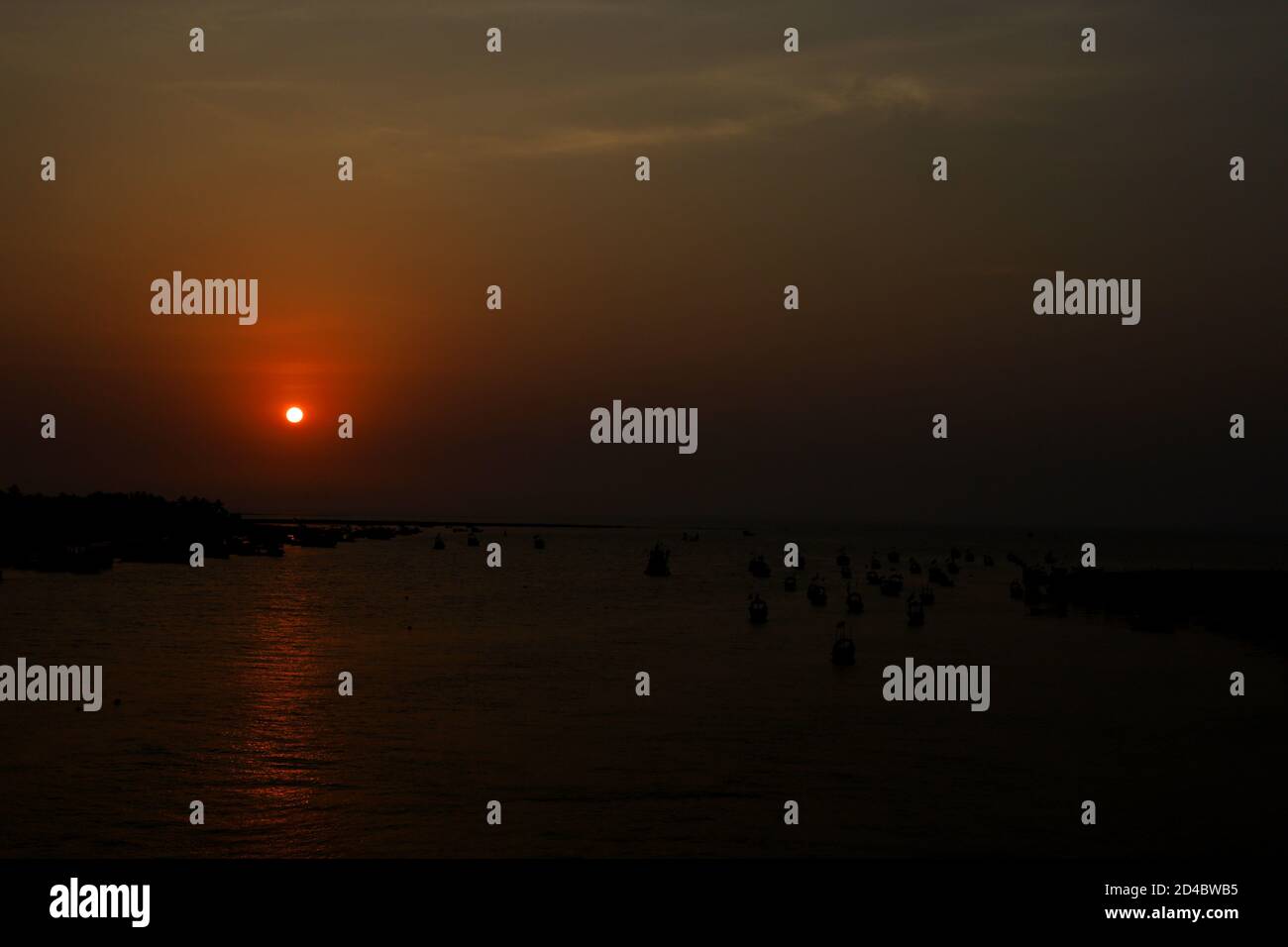 Der Sonnenuntergang an einem schönen Strand, der von Menschen überfüllt ist Stockfoto