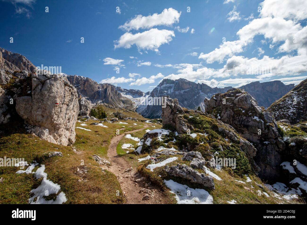 Ein Wanderweg schlängelt sich durch die Steine der Dolomiten, Richtung Berge am Horizont, in der Geisler-Gruppe, Südtirol, Italien Stockfoto