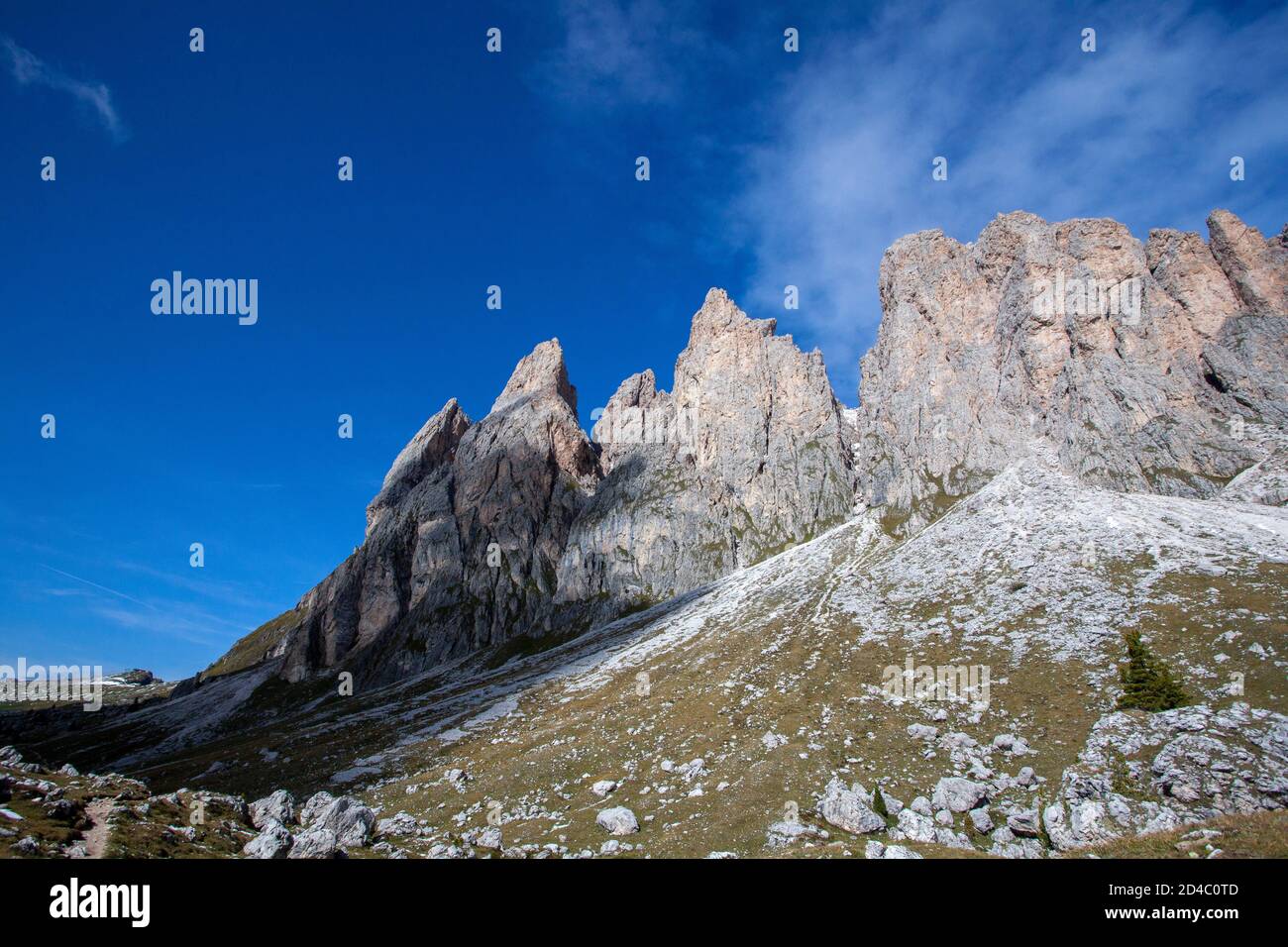 Die schroffen Gipfel der Geisler-Gipfelgruppe in den italienischen Dolomiten, in den Südtiroler Alpen, Italien, erheben sich vor einem meist blauen Himmel Stockfoto