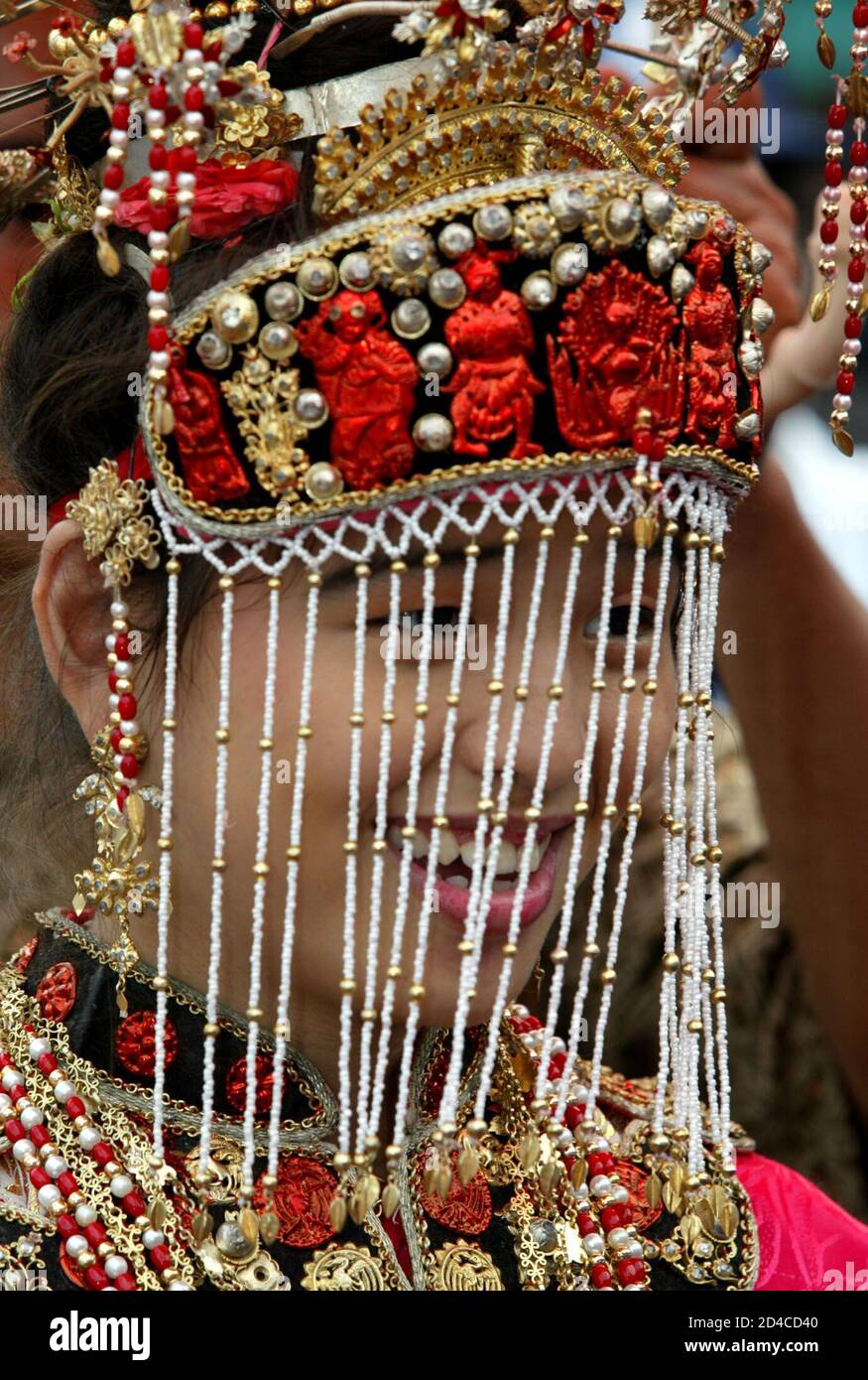 Eine Frau trägt die traditionelle Peranakan-Kleidung während eines Festivals einen Tag nach der CHAP-Goh-Meh-Feier, die das Ende des chinesischen Neujahrs markiert, in Jakartas Chinatown am 16. Februar 2003. Lokale Medien sagten, dass die Feierlichkeiten, zu denen auch eine Parade in Jakarta mit zehntausenden Teilnehmern gehörte, die ersten offenen Cap-Goh-Meh-Feierlichkeiten waren, seit chinesische kulturelle Aktivitäten vor 40 Jahren verboten wurden. Die Peranakans sind Nachfahren einer frühen chinesischen Gemeinschaft, die sich ab dem 17. Jahrhundert im malaiischen Archipel niederließ. REUTERS/Darren Whiteside Stockfoto