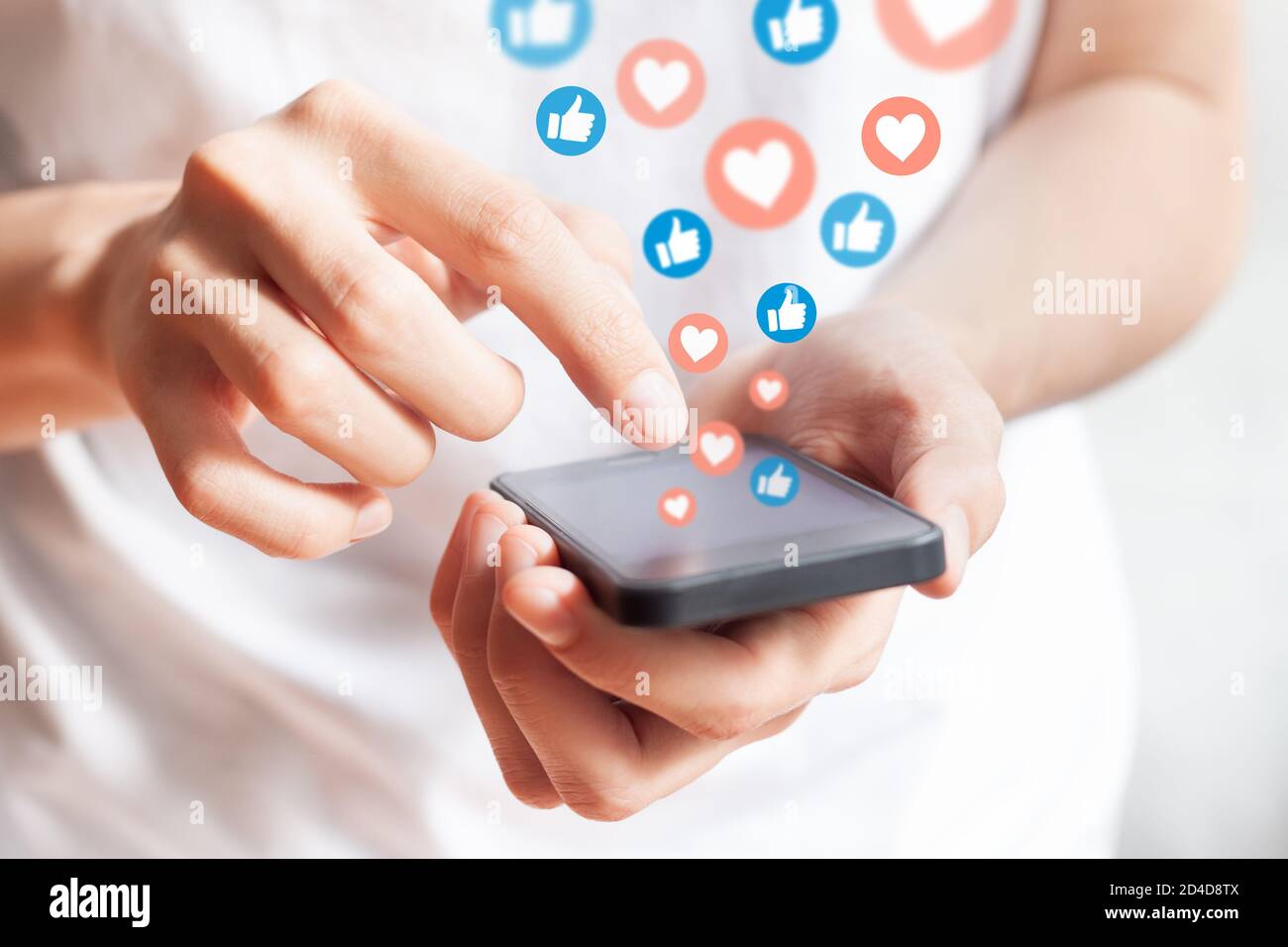 Person, die in sozialen Netzwerken mit dem Smartphone interagiert, indem sie Beiträge mit „Gefällt mir“ und „Liebe“ aufführt. Werbung auf dem Handy durch Erhebung von Nutzerdaten und Targeti Stockfoto