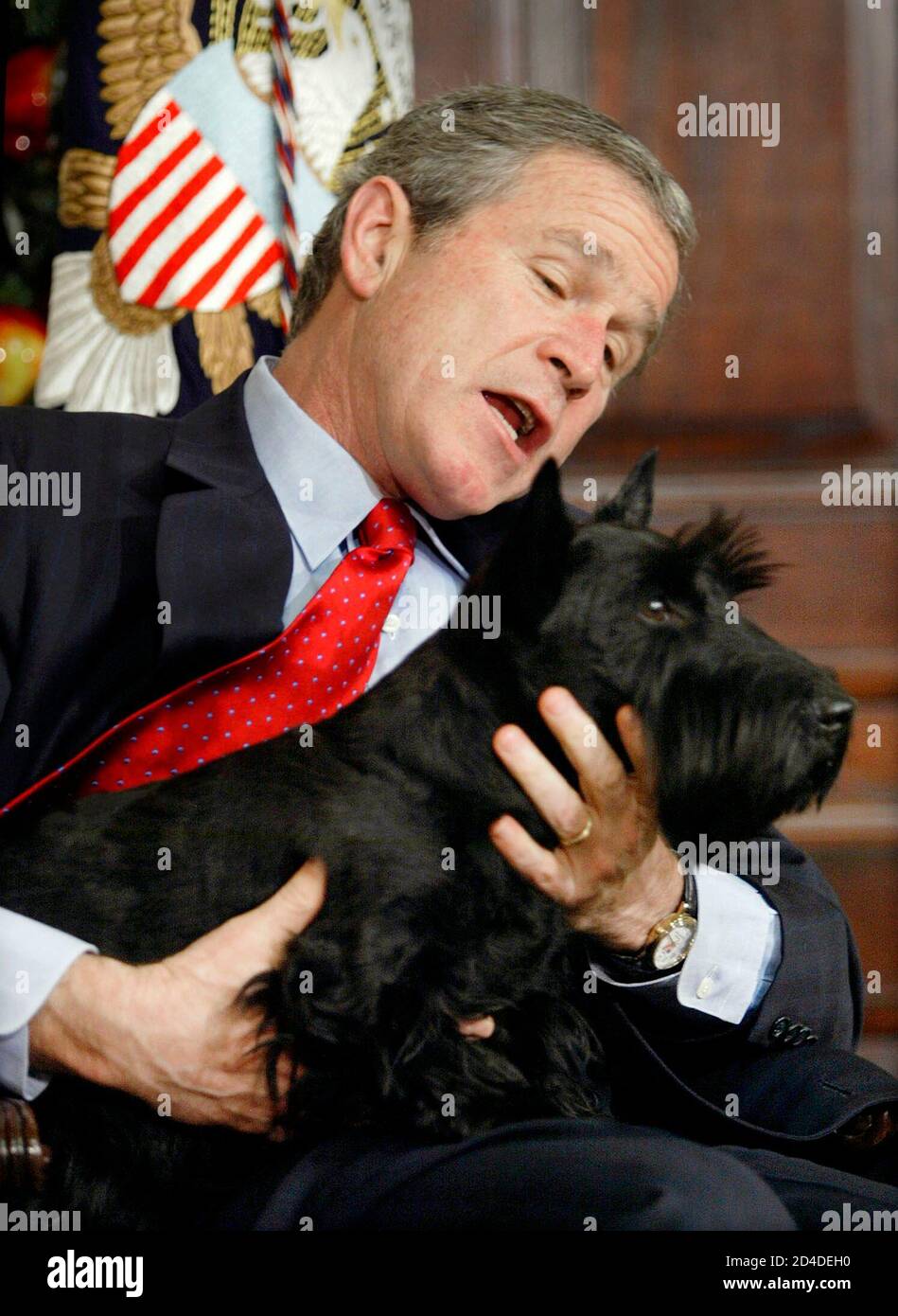 US-Präsident George W. Bush hält an seinem Hund Barney fest, nachdem das Haustier des Weißen Hauses unerwartet hereinkam und einige Schüler Raum Washington während einer Lesung einer Weihnachtsgeschichte im Roosevelt-Zimmer des