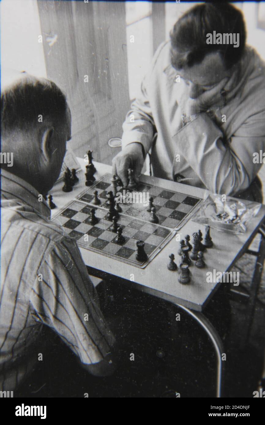 Feine 70er Jahre Vintage Schwarz-Weiß-Fotografie von zwei alten Männern, die ein ernstes Schachspiel spielen. Stockfoto