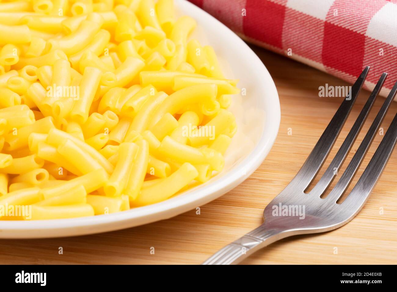 Teller voll mit köstlichen Macaroni und Käse auf einem hölzernen Hintergrund Stockfoto