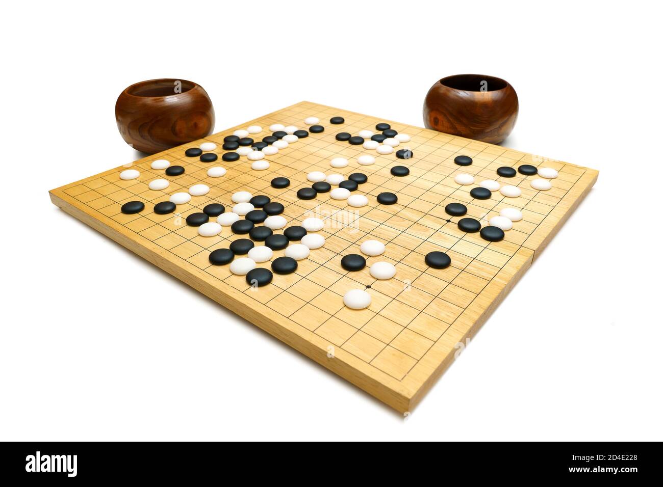 Schwarze und weiße Steine auf einem 'GO' Brett aus Holz auf weißem  Hintergrund - traditionelle chinesische Strategie Brettspiel (genannt Baduk  in Korea, Weiqi in C Stockfotografie - Alamy