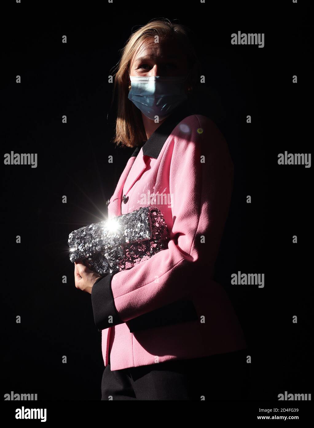 MEG Randell, Head of Designer Handbags and Fashion bei Bonhams, Models a Chanel pink and black Crepe Blazer, c.. 1990, Schätzung £ 400 - 600, und ein Chanel Silber Pailletten East West Flap Tasche, c. 2015, Schätzung £ 1,500 - 2,000, während einer Vorschau auf Bonhams' Designer-Handtaschen und Modeverkauf, Bonhams, London. Im Oktober 13 werden 20 klassische Hermes Kelly Taschen und die persönliche Handtaschenkollektion von Barbara Taylor Bradford angeboten. Stockfoto