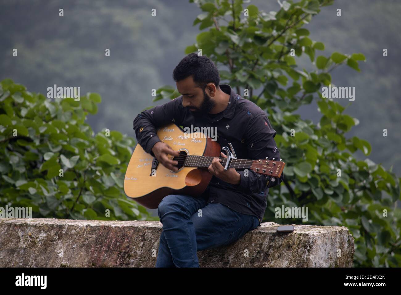 Dehradun, Uttarakhand/Indien-September 12 2020:EIN junger Gitarrist in wunderschönen Hügeln. Stockfoto