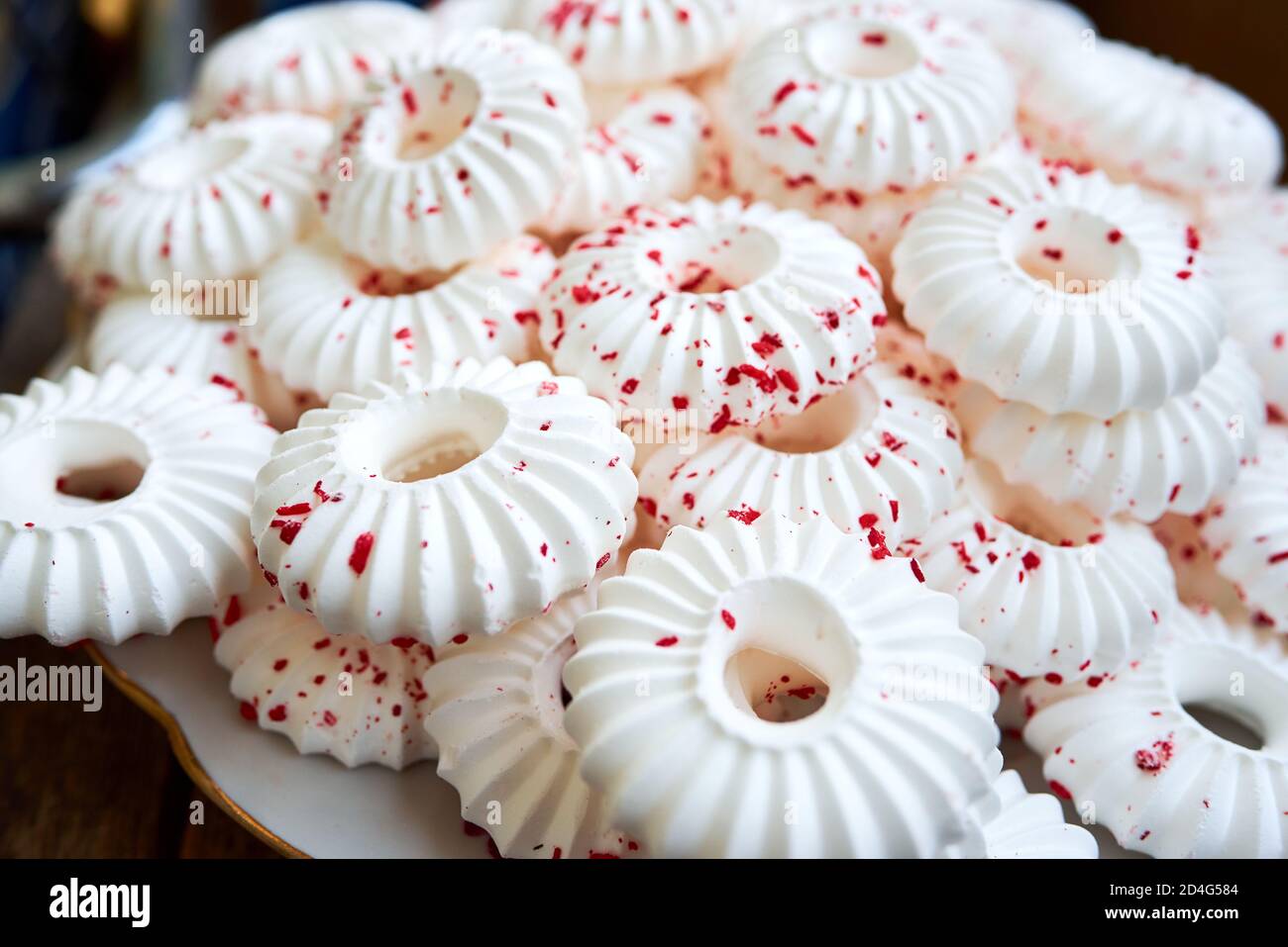 Hintergrund von weißen Baiser Kuchen mit roten Gebäck Krümel bestreut Stockfoto
