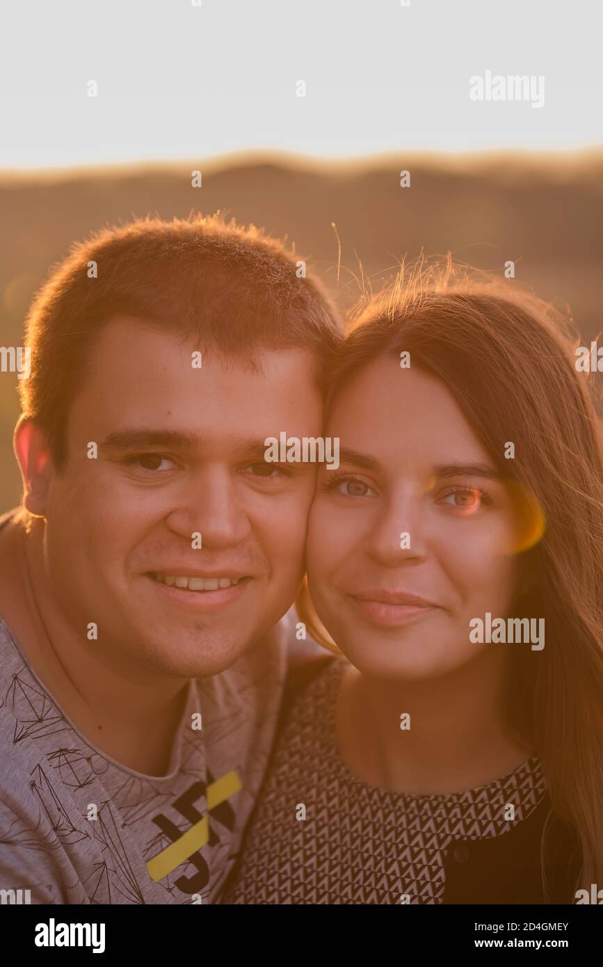 Ein sehr nahes Porträt eines verliebten Paares drückte ein junger Mann seine Wange an die Wange einer schönen Dame. Liebhaber sind glücklich, lächelnd, schauen Herbst Stockfoto