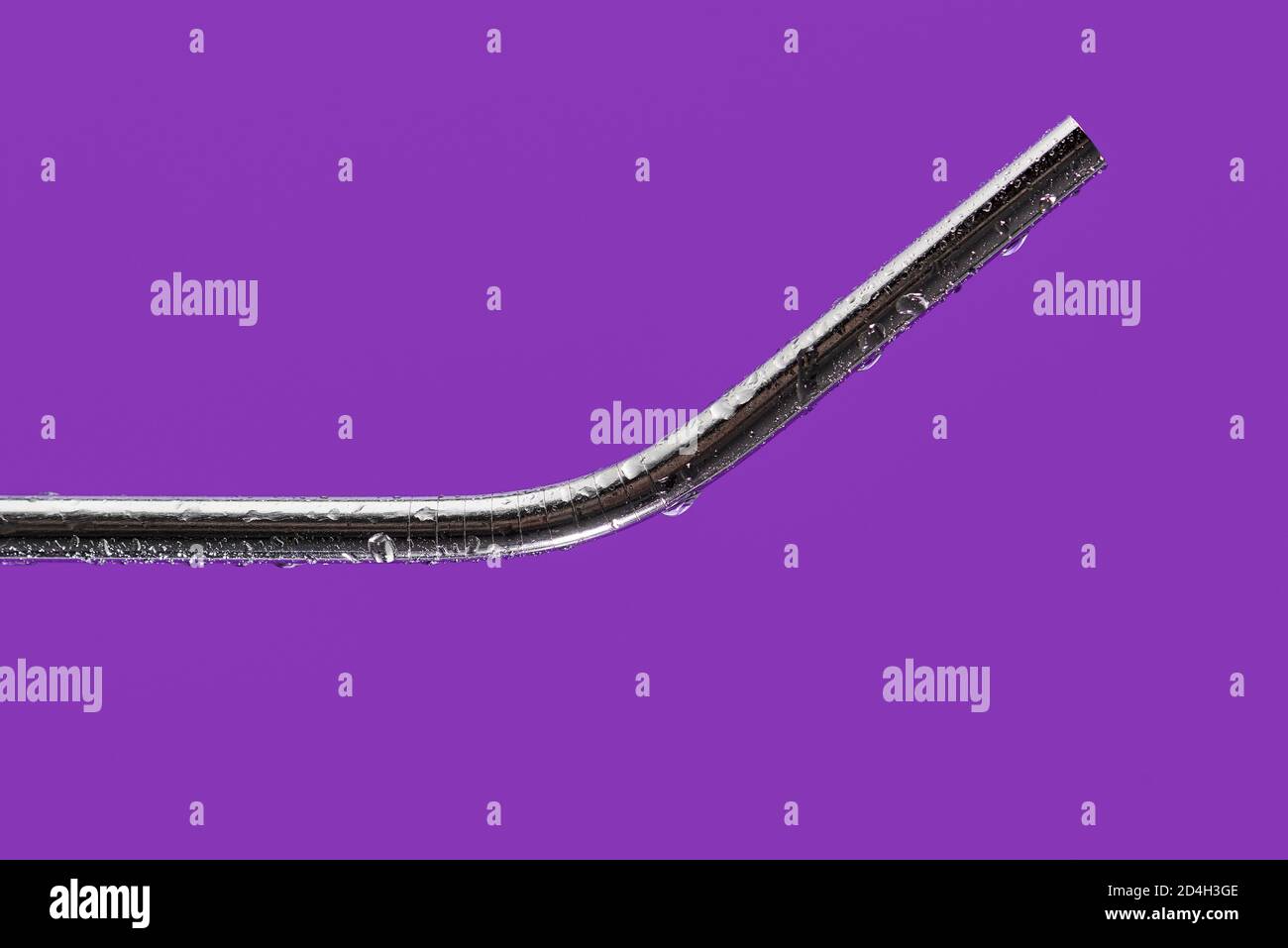 Nahaufnahme eines wiederverwendbaren Trinkhalms aus Edelstahl auf einem Violetter Hintergrund Stockfoto