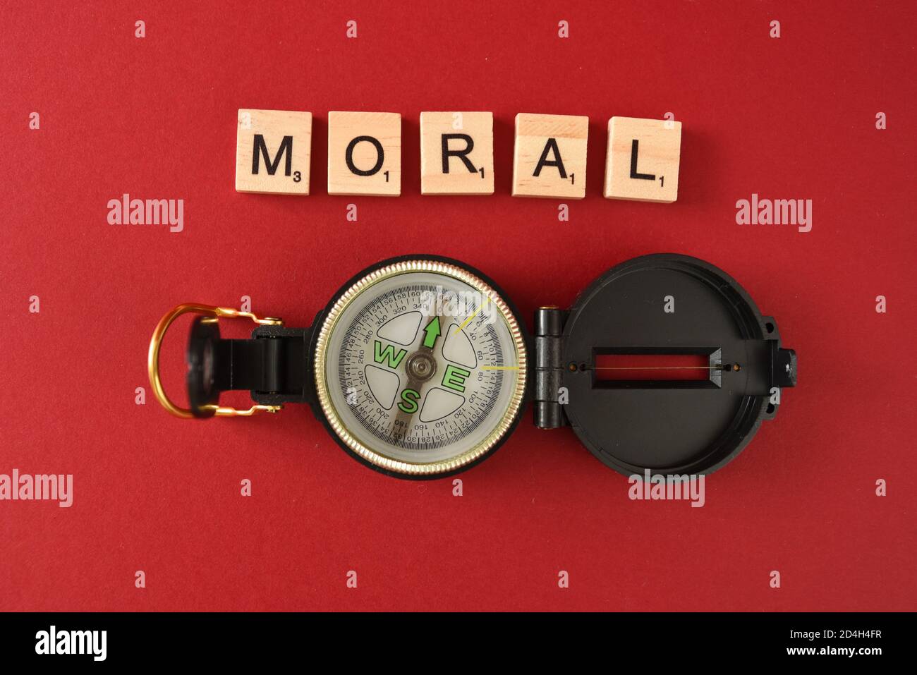 Moralischer Kompass mit einem Kompass und Kacheln mit Buchstaben auf Stockfoto