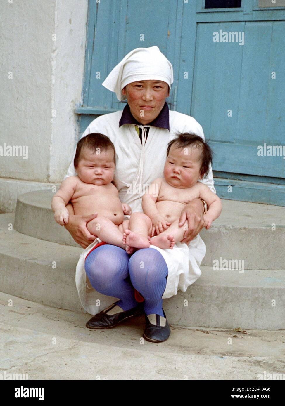 Krankenschwester mit Zwillingen in den Armen in der ostmongolischen Stadt Baruun-Urt, aufgenommen 1977 Stockfoto