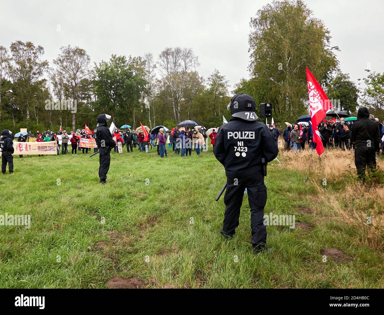Eschede, 26. September 2020: Lockere Schnur deutscher Polizeibeamter in schwarzen Kampfuniformen vor einer Gruppe von Demonstranten Stockfoto