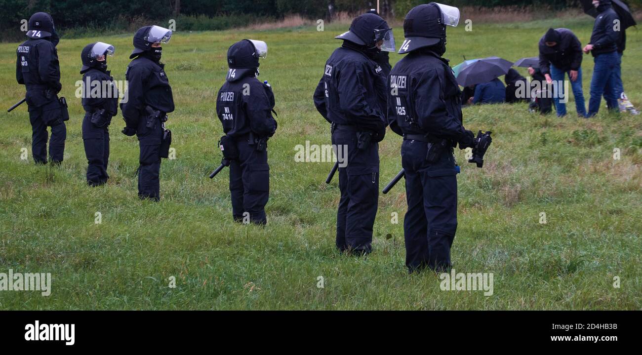 Eschede, 26. September 2020: Polizisten in schwarzen Kampfuniformen bilden eine Linie, um einen Eingang zu einer Wiese zu blockieren Stockfoto