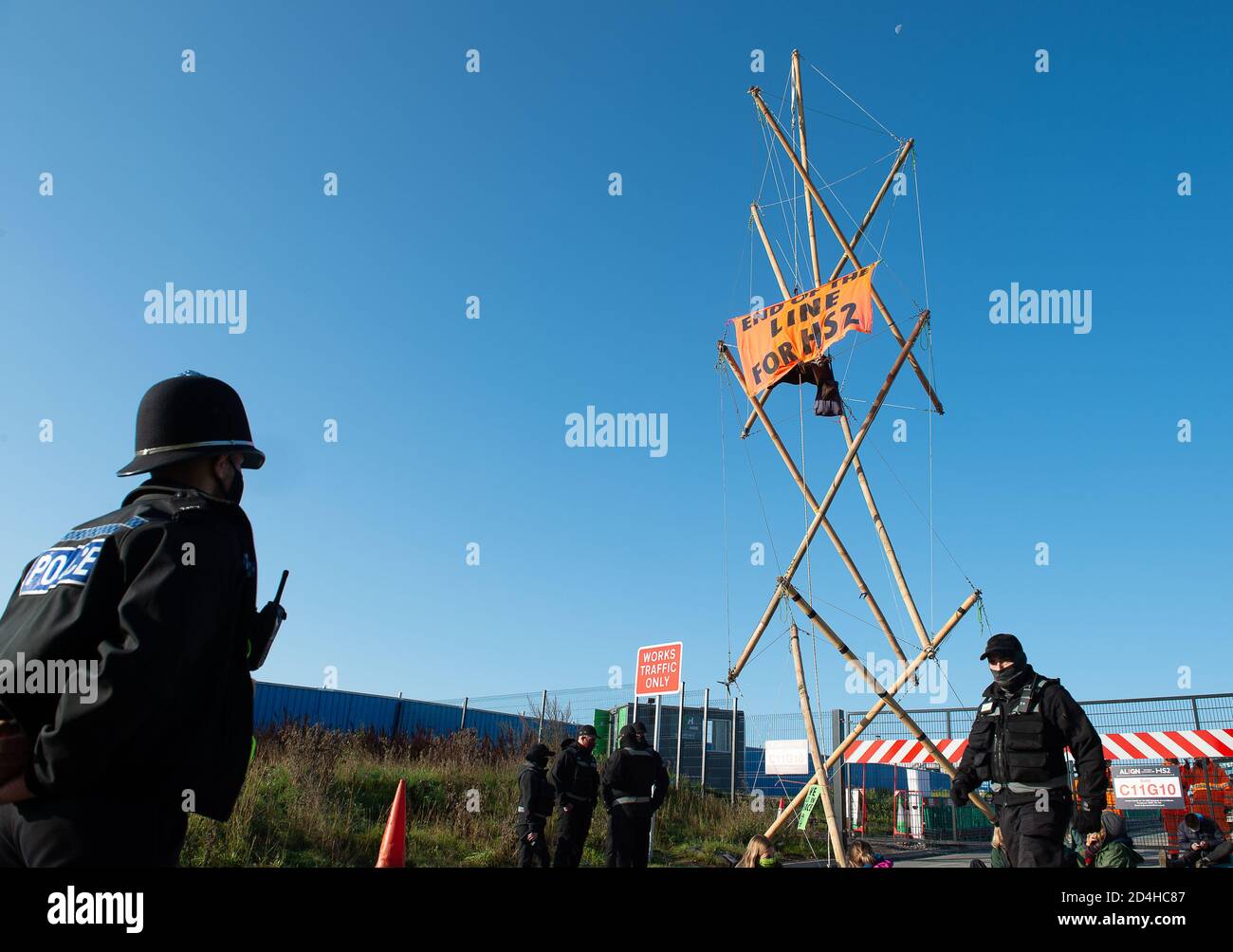 West Hyde, Hertfordshire, Großbritannien. Oktober 2020. HS2 Rebellion and Extinction Rebellion Umweltaktivisten blockierten heute alle Eingänge zur 135 Hektar großen HS2-Baustelle in West Hyde, um gegen die Umweltauswirkungen der HS2-Hochgeschwindigkeitsstrecke zu protestieren. Einige der Protestierenden hatten ihre Arme in Rohrleitungen zusammengebunden, während andere an hohen Bambusbake-Strukturen hingen. Sie schickten eine Botschaft von Taten, nicht Worte an Boris Johnson über seine eigenen Worte, dass "Aussterben für immer ist, so dass unsere Aktion muss sofort sein". Quelle: Maureen McLean/Alamy Live News Stockfoto