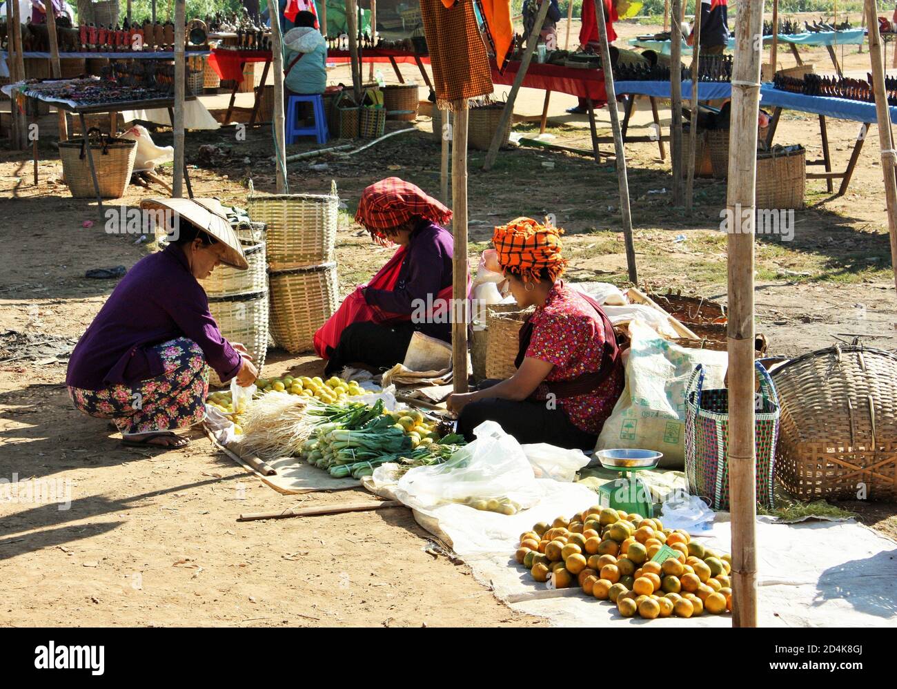 Inle Lake, Shan State / Myanmar - 18. Dezember 2019: Lokale Pa'O Ethnie in traditioneller Kleidung an einem Gemüsestände auf Phaung Daw Oo Markt Stockfoto