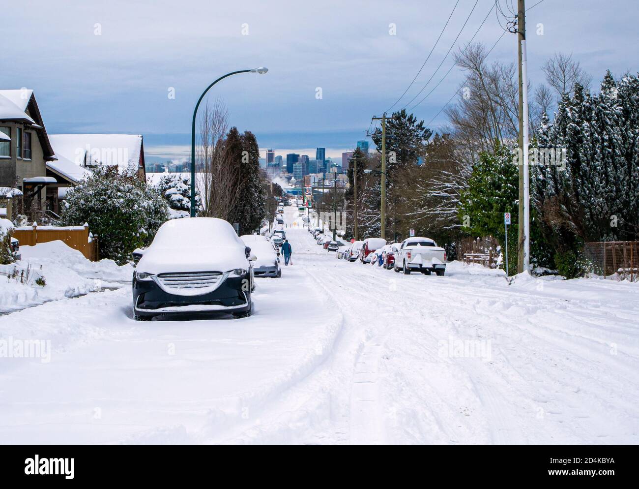 Wohnstraße nach einem schweren Schneesturm. Vancouver, British Columbia, Kanada. Straße ist nicht gepflügt und viele geparkte Autos mit Schnee bedeckt. Ein pe Stockfoto