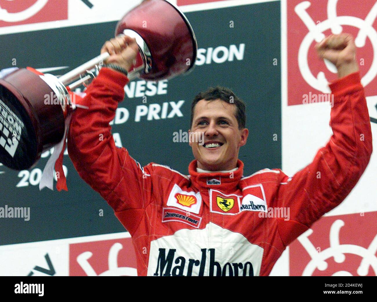 Michael Schumacher Deutschland wirft seine Trophäe, wie er seinen Sieg in  der Formel Eins japanischen Grand Prix und der Fahrer WM-Titel auf dem  Suzuka Circuit 8. Oktober 2000 feiert. [Mika Häkkinen Finnlands