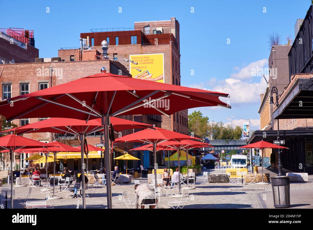 Rote Schirme in Gansevoort Plaza, einem öffentlichen Außenbereich in der West Side von Manhattan, an der Kreuzung von vier Straßen. Stockfoto