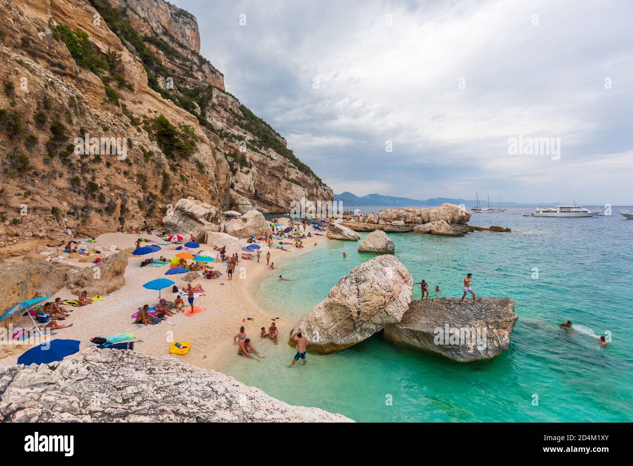 Cala Mariolu, Sardinien. 03. August 2020: Strand in einer natürlichen Bucht auf Sardinien in Italien. Zahlreiche Menschen im Urlaub während des Sommers. Felsenküste Stockfoto