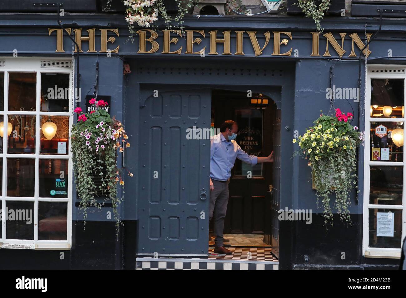 Ein Mann schließt das Beehive Inn im Grassmarket in Edinburgh, da ab 18 Uhr am Freitag temporäre Beschränkungen in Kraft treten, die von der ersten Ministerin Nicola Sturgeon angekündigt wurden, um die Ausbreitung des Coronavirus einzudämmen. Stockfoto