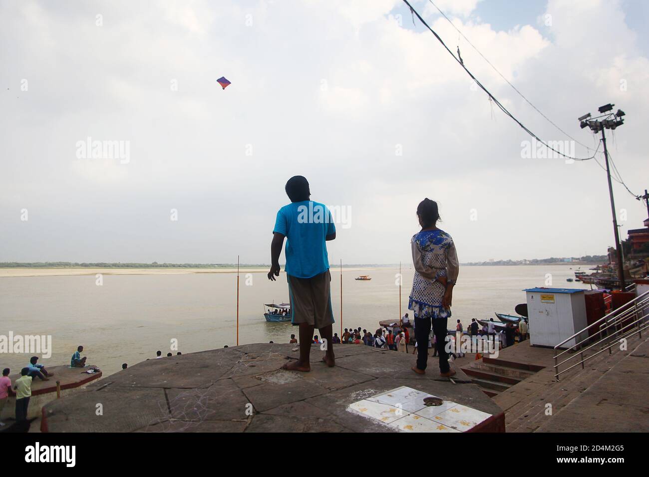 Kinder fliegen einen Drachen am Ganges Fluss in Varanasi, Indien Stockfoto