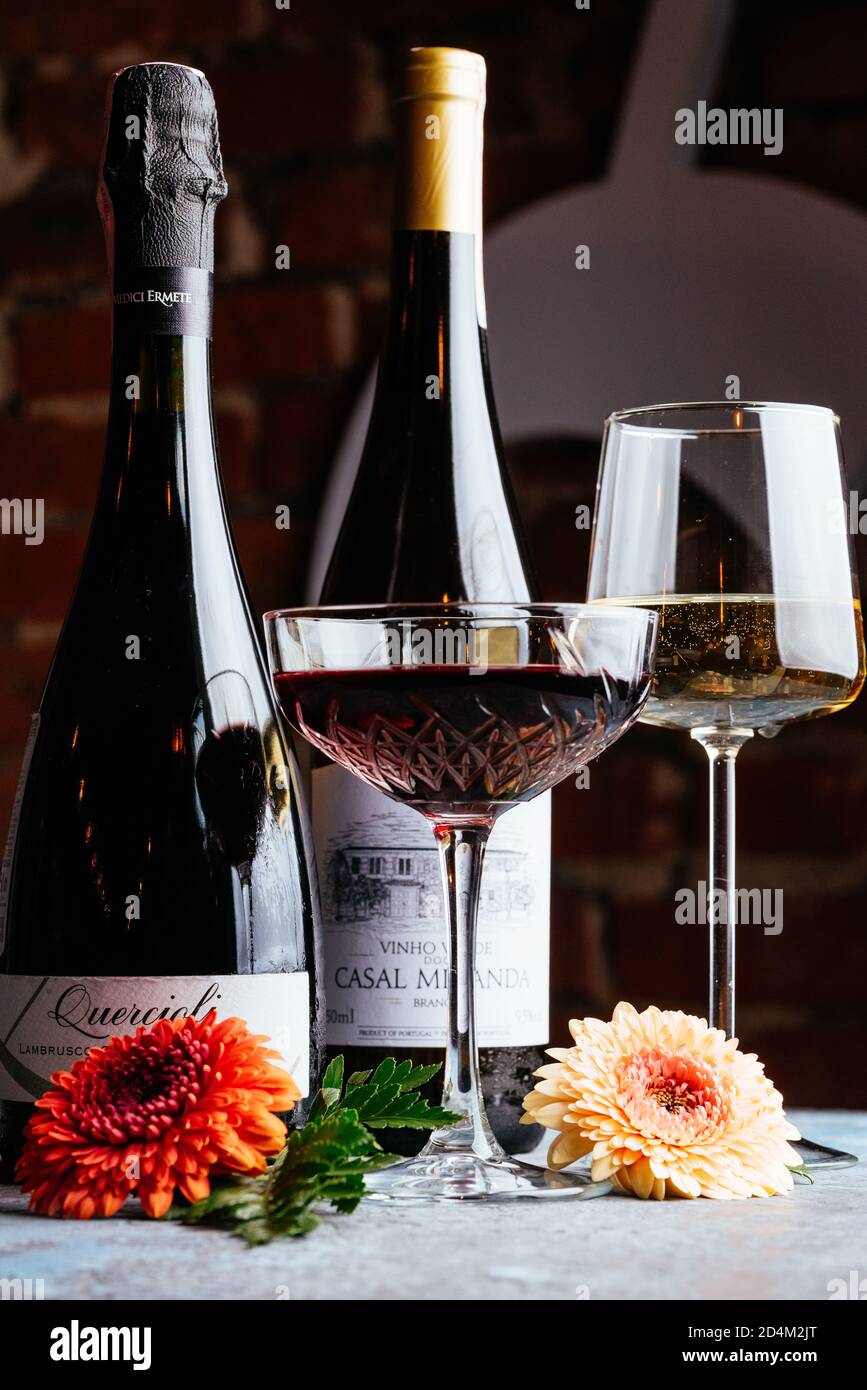 Rot-und Weißwein auf vintage blauen Hintergrund mit natürlichen Blumen Stockfoto