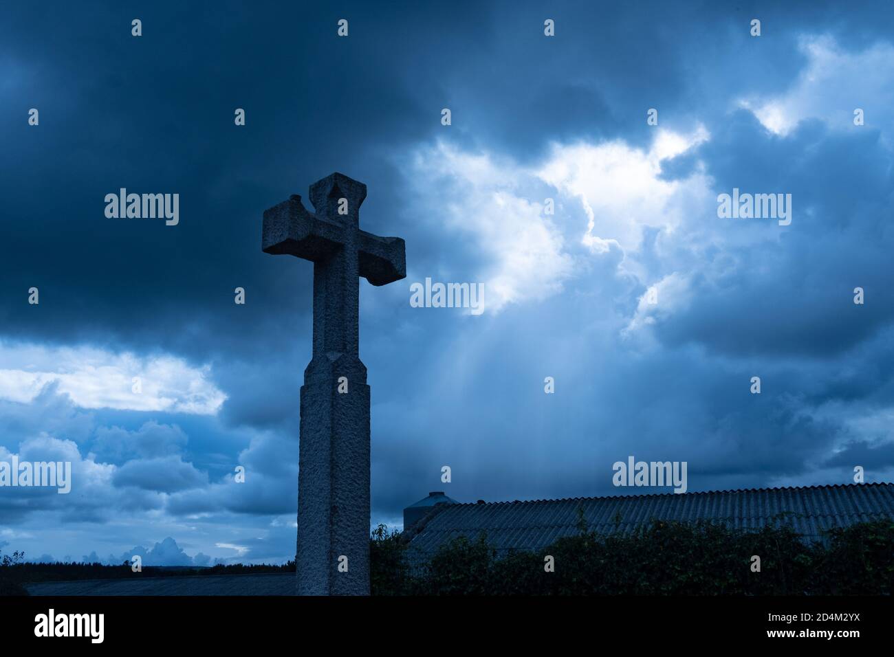 christliches Kreuz gegen dramatischen düsteren dunklen Himmel, mit Sonnenstrahlen kommen durch düstere Wolken der großen Flut, Konzept des letzten Gerichts oder Apokalypsen Stockfoto