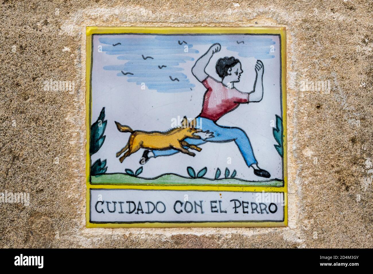 Spanier hüten sich vor den Hundefliesen an der Außenseite eines Gebäudes. Stockfoto
