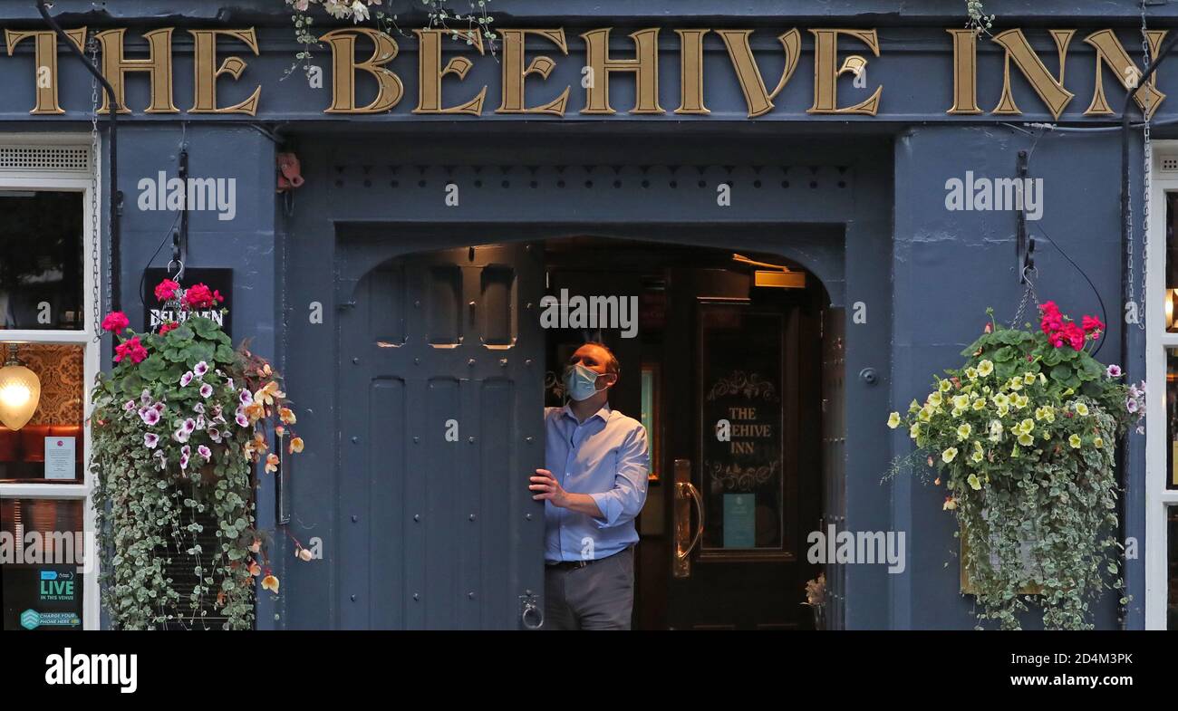 Ein Mann schließt das Beehive Inn im Grassmarket in Edinburgh, da ab 18 Uhr am Freitag temporäre Beschränkungen in Kraft treten, die von der ersten Ministerin Nicola Sturgeon angekündigt wurden, um die Ausbreitung des Coronavirus einzudämmen. Stockfoto