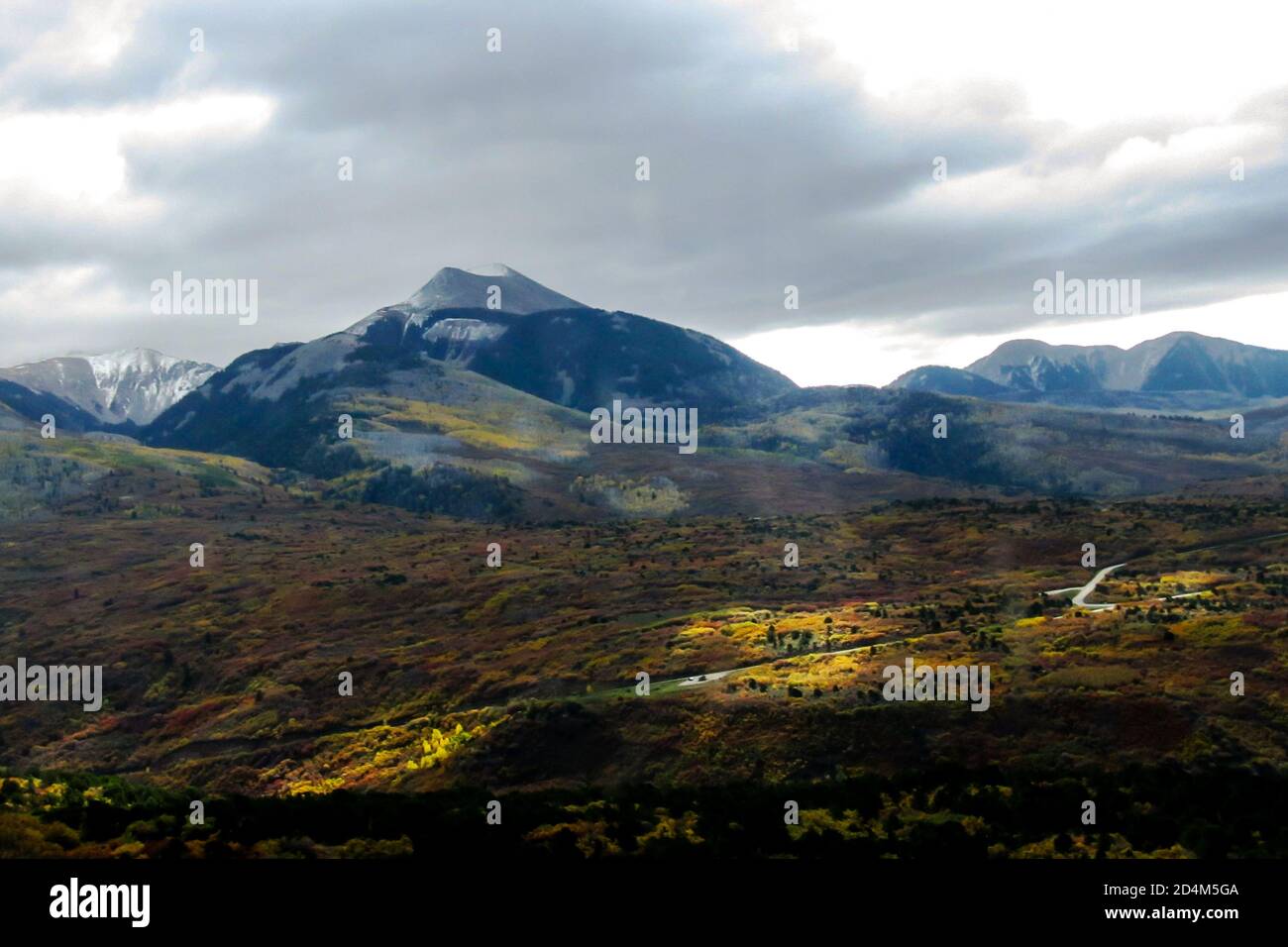 Blick auf die schneebedeckten Gipfel der La Sal Mountains in Utah, West USA, Brush Oak im Herbst Laub im Vordergrund, beleuchtet von Sonneneinstrahlung Stockfoto