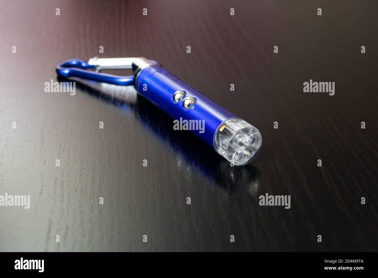 Blauer Laserpointer auf einem Holzhintergrund Stockfoto