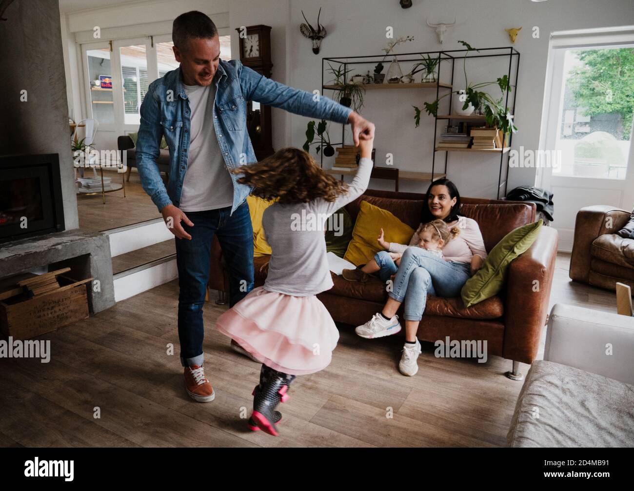 Junge Familie zusammen, Vater und Tochter tanzen in der Lounge Stockfoto