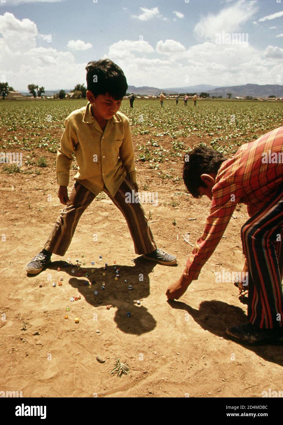 Die Kinder von Wanderarbeitern spielen Murmeln, während ihre Eltern auf Feldern arbeiten - Ort: In oder in der Nähe von Ft. Collins; Colorado Ca. 1972 Stockfoto