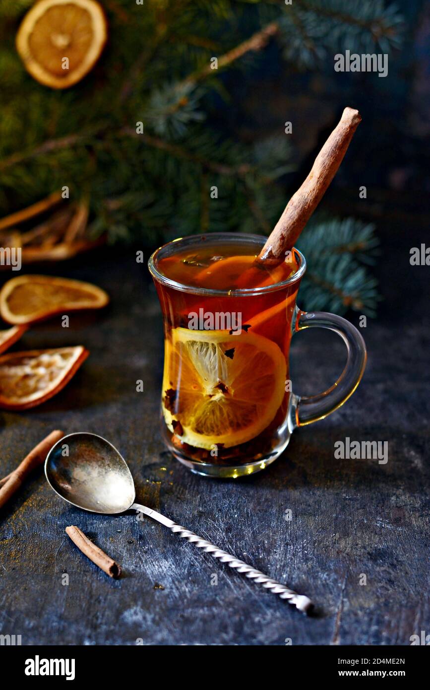 Weihnachten Tee mit Orange und Gewürzen. Selektive konzentrieren. Hot  würzigen Tee auf Fach mit Zweigen von Nadelholz Baum. Weihnachten Konzept  auf dunklem Holz backgr Stockfotografie - Alamy
