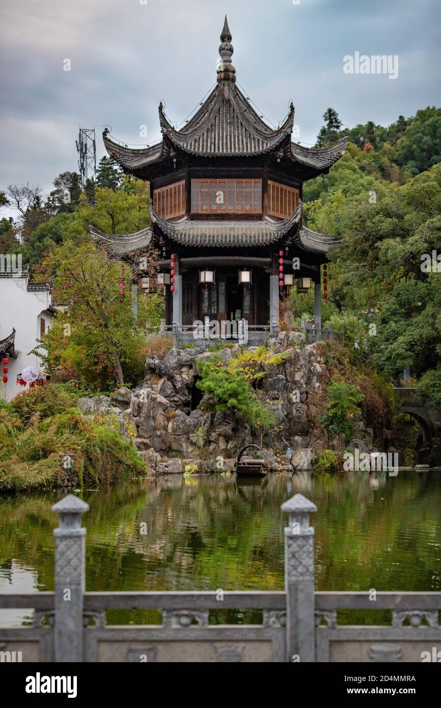 Vertikale Aufnahme eines japanischen Tempels umgeben von Pflanzen und Ein See Stockfoto