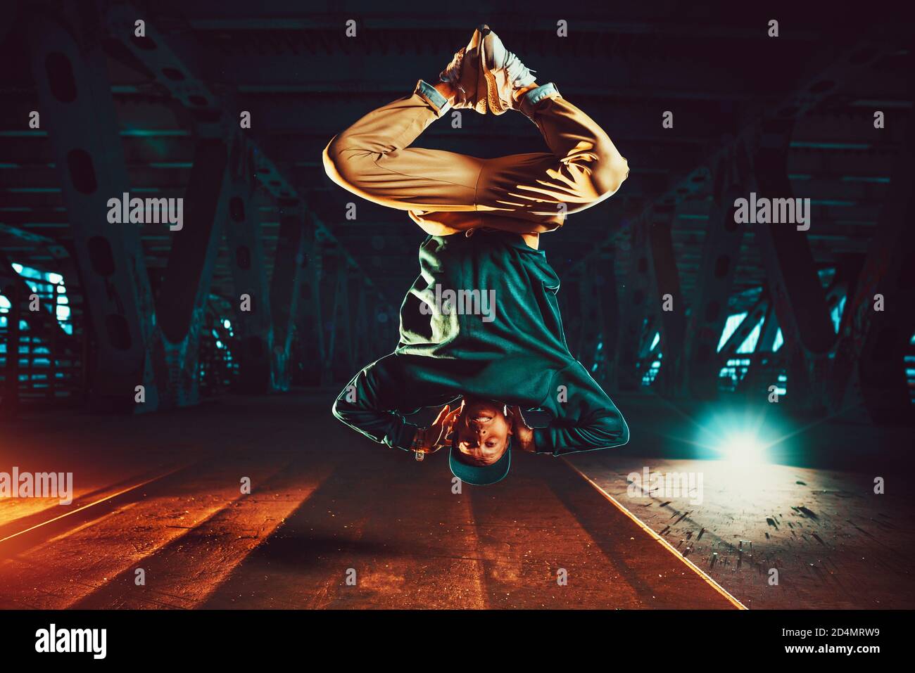 Junge coole Mann brechen Tänzer springen auf den Kopf. Urban Brücke mit kühlen und warmen Licht Hintergrund. Stockfoto