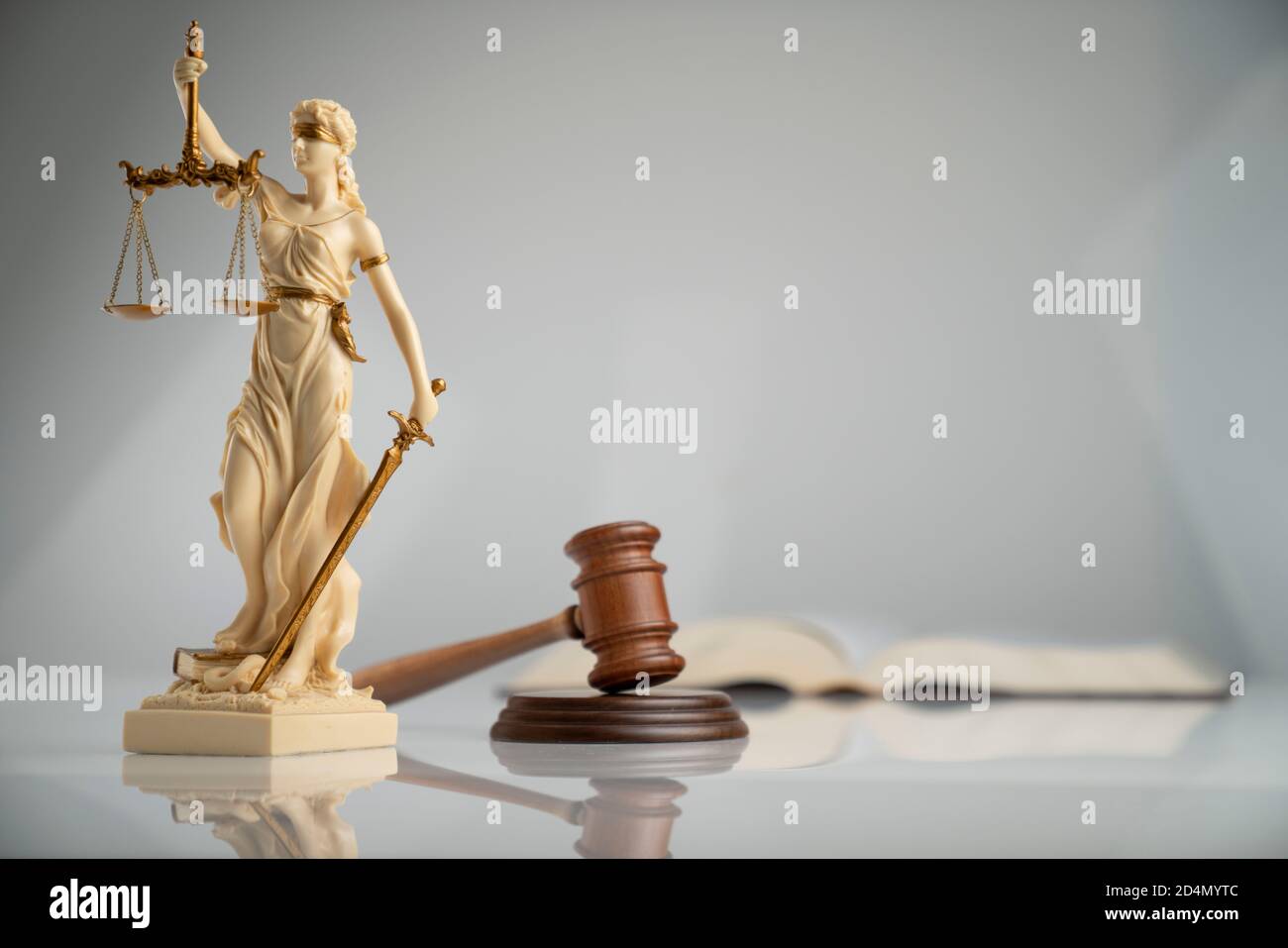 Zusammensetzung der Rechtssymbole. Themis Statue, Richter Gavel und Maßstab der Gerechtigkeit auf weißem Tisch auf off-weißen Hintergrund. Stockfoto