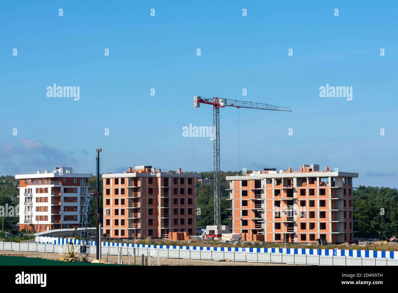 Turmdrehkran auf einer Baustelle. Bau von Hochhäusern mit mehreren Wohnungen. Neues Gebäude. Stockfoto