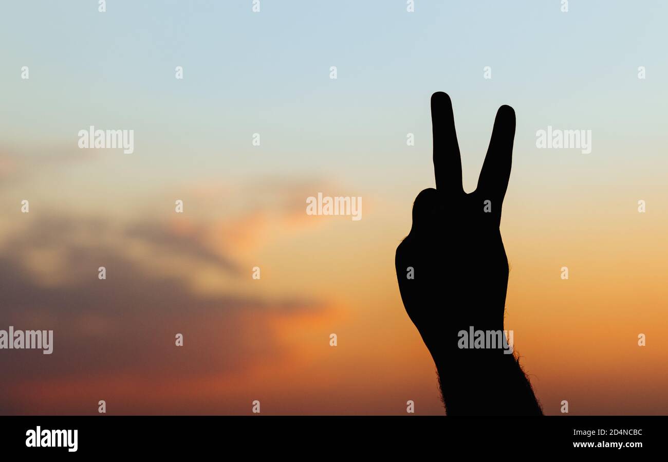 Hand des Menschen isoliert auf Himmel Hintergrund - Frieden Geste Silhouette Stockfoto