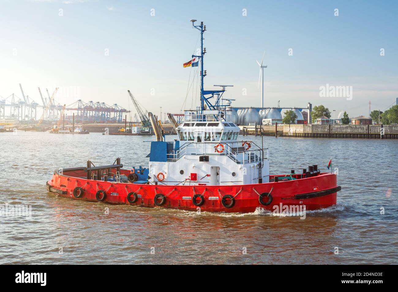 Roter Schlepper auf der Elbe vor den Hafenanlagen in Hamburg Stockfoto